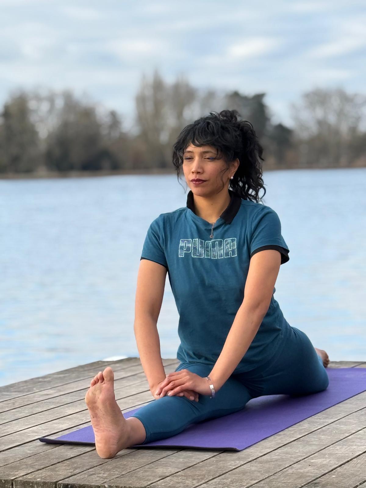Célia Mouëtron pratiquant le yoga au bord de l’eau lors d’un stage Yoga Marga